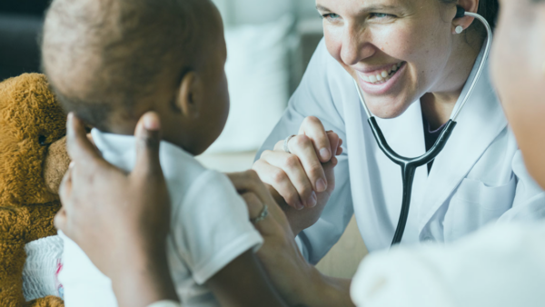 A clinician smiling at a young child