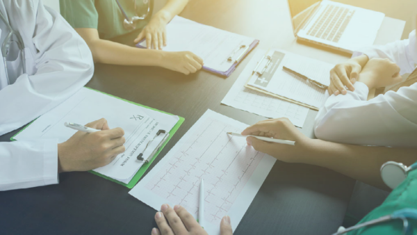 A group of healthcare leaders reviewing papers around a table