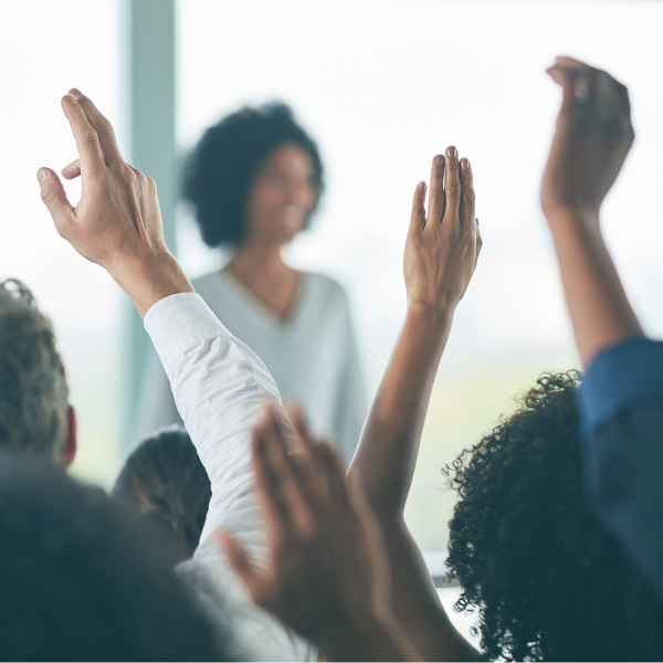 A set of raised hands at a conference